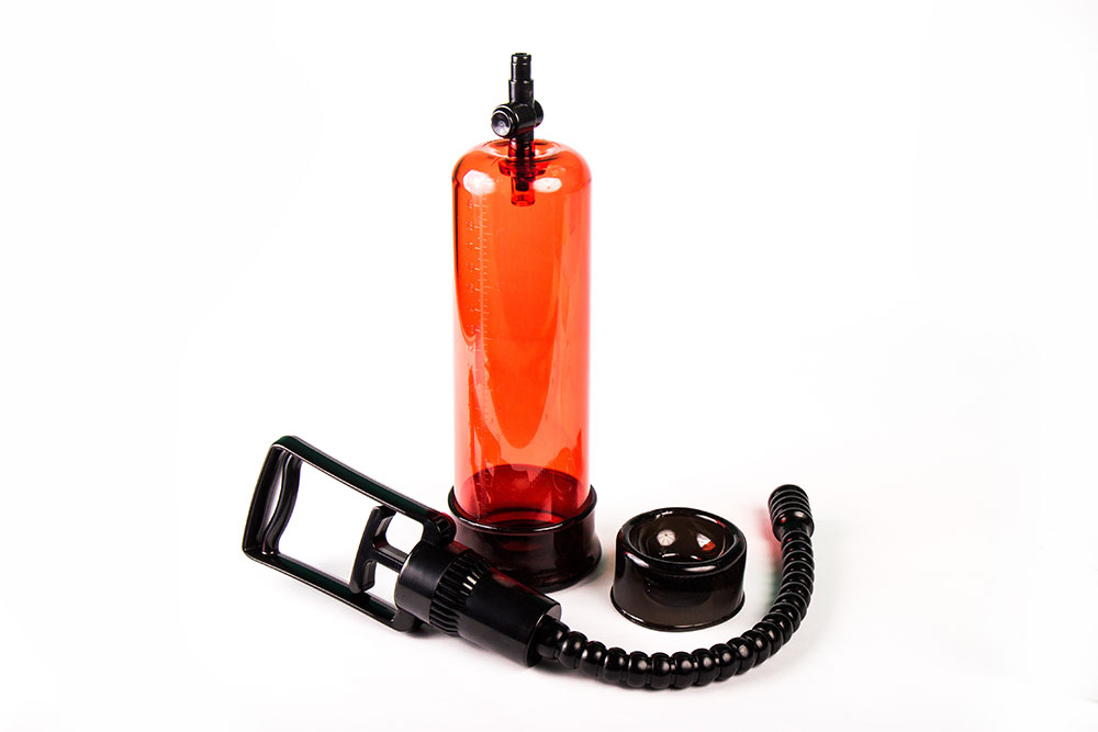 Penispumpenset mit rot-transparentem Zylinder auf weißem Hintergrund