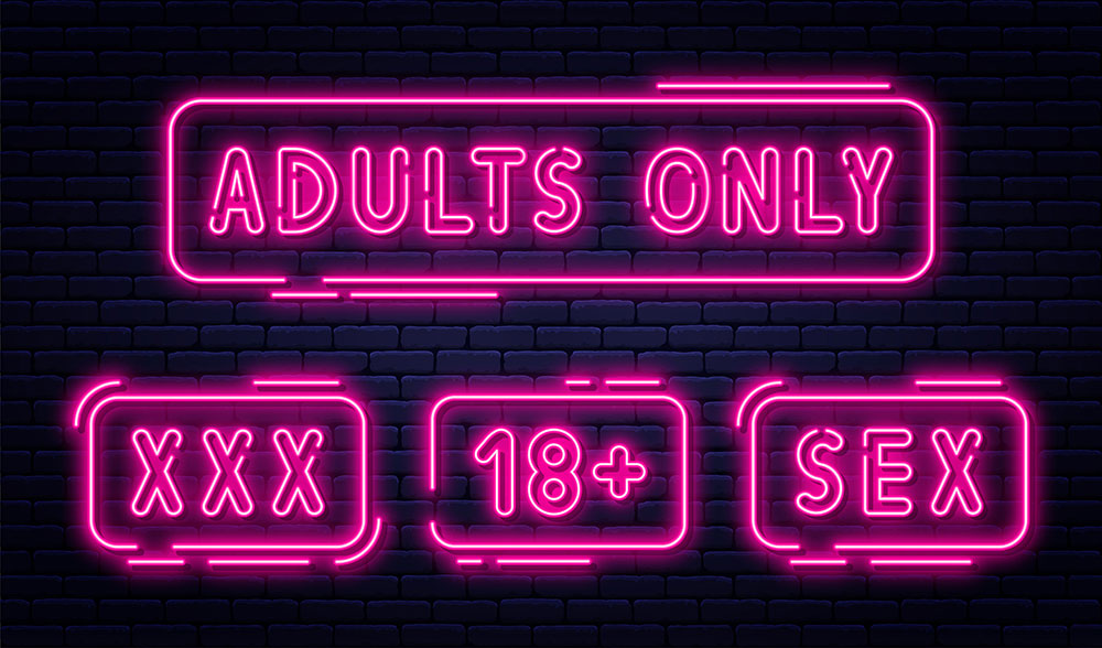 Dunkle Ziegelmauer mit pinker Leuchtschrift Adults only, XXX, 18+, SEX