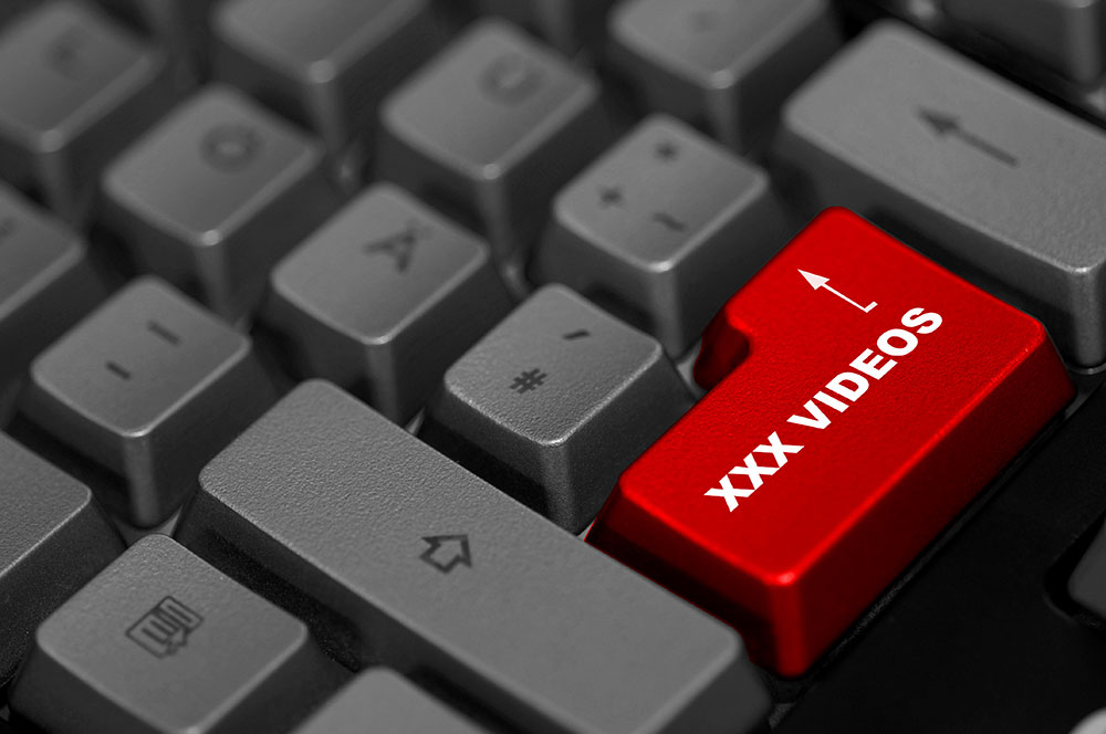 S/W-Nahaufnahme einer Tastatur mit roter Entertaste und XXX VIDEOS Beschriftung