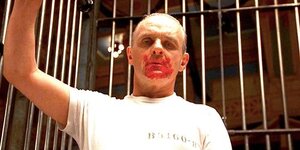 hannibal-lecter-stares-down-with-a-bloodstained-mouth-inside-a-cage-in-silence-of-the-lambs.jpg