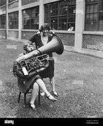 frau-spielt-eine-tuba-und-eine-andere-frau-horen-kann-1928-2ab7bg5.jpg